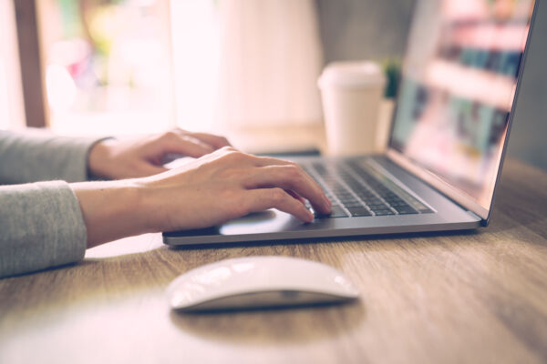 Person sitz bei Laptop und wartet auf Webinar